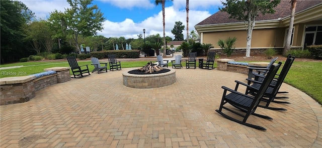 view of property's community featuring an outdoor fire pit and a patio