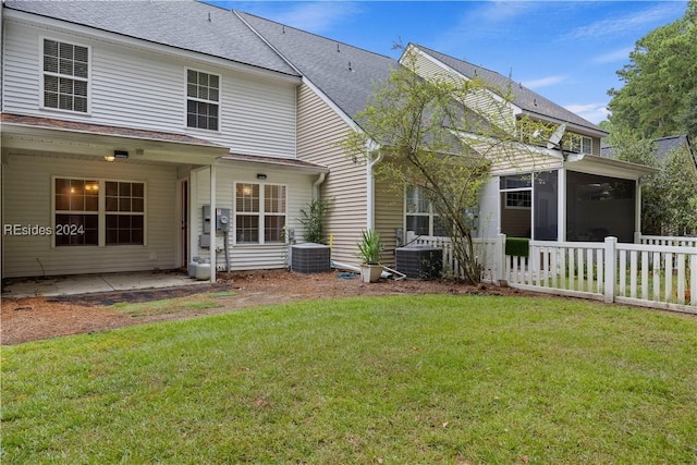 back of house with a yard, a patio area, a sunroom, and central air condition unit