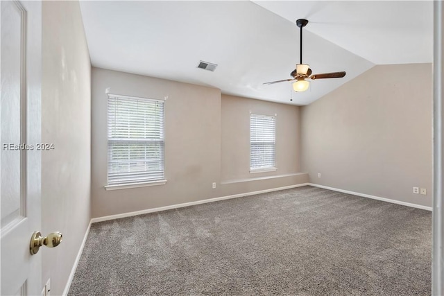 carpeted spare room featuring ceiling fan and vaulted ceiling