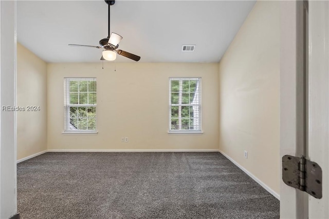 spare room with ceiling fan and dark colored carpet