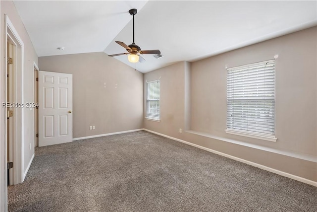 unfurnished bedroom featuring ceiling fan, lofted ceiling, carpet floors, and multiple windows