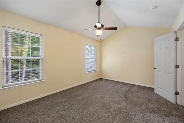 carpeted spare room featuring vaulted ceiling, ceiling fan, and plenty of natural light