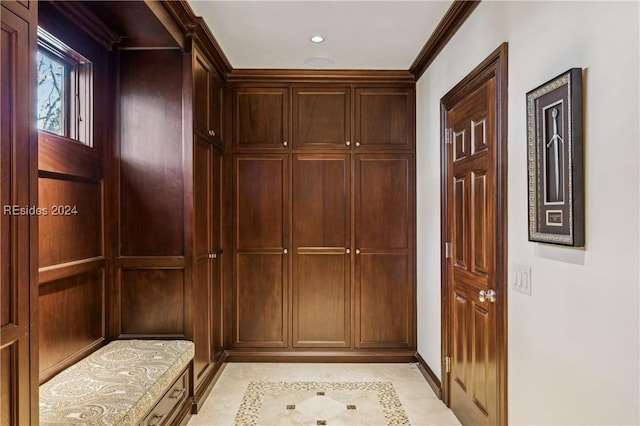 mudroom featuring crown molding and light tile patterned floors