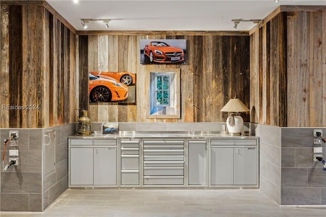 interior space with track lighting and wood walls