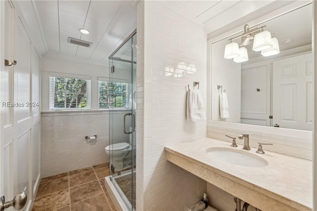 bathroom featuring tile walls, sink, toilet, and walk in shower