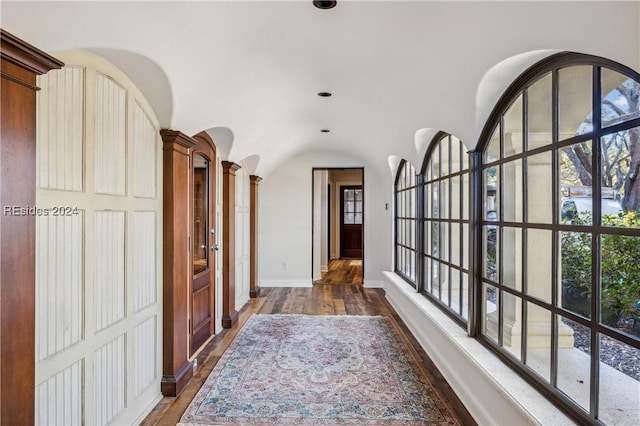 hallway with dark wood-type flooring and ornate columns