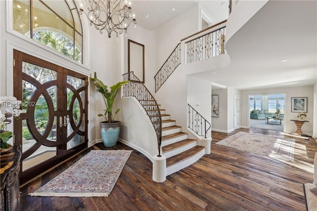 foyer entrance with a high ceiling, dark wood-type flooring, and french doors