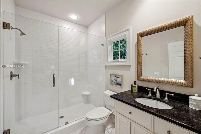 bathroom featuring vanity, a shower with shower door, and toilet