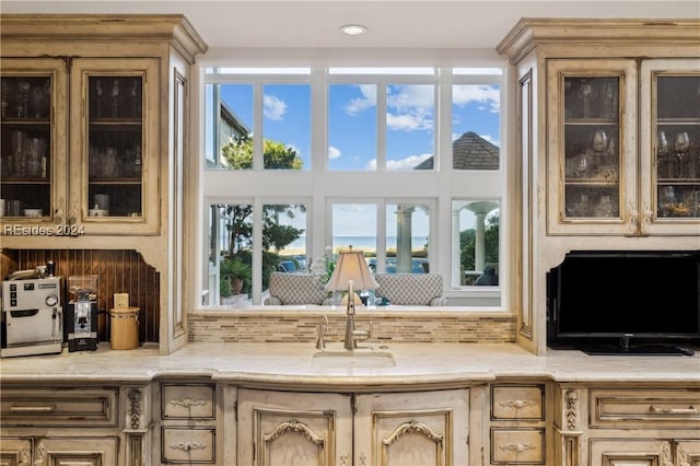 interior space featuring sink, backsplash, and a towering ceiling