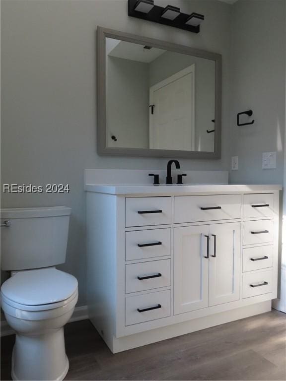 bathroom featuring vanity, hardwood / wood-style floors, and toilet