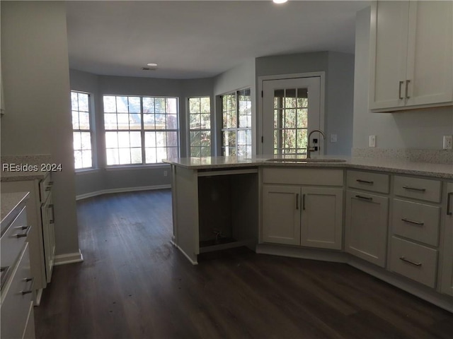 kitchen featuring white cabinetry, sink, dark wood-type flooring, and kitchen peninsula