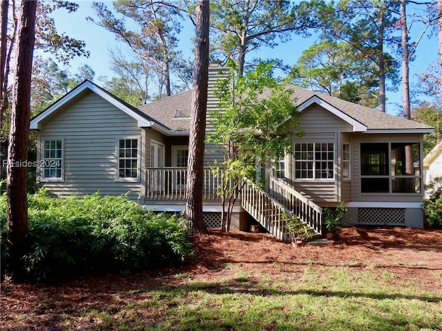 rear view of property featuring a sunroom