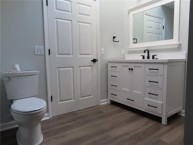 bathroom featuring hardwood / wood-style flooring, vanity, and toilet