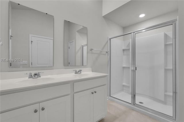 bathroom featuring vanity and a shower with door