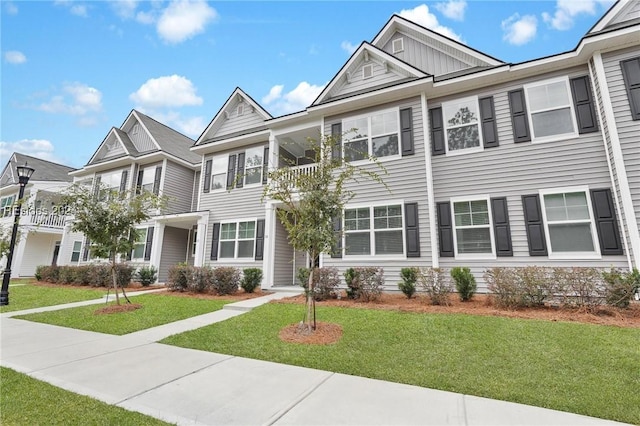 townhome / multi-family property with a front lawn