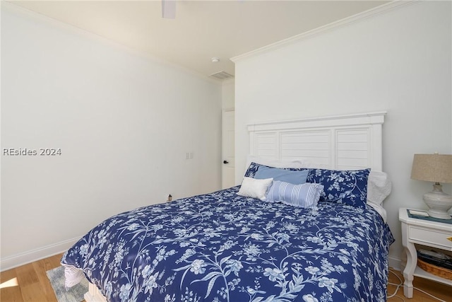 bedroom with hardwood / wood-style flooring and ornamental molding