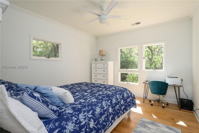 bedroom with hardwood / wood-style floors, ornamental molding, and ceiling fan