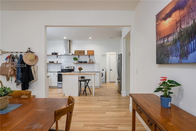 dining space featuring washer / dryer and light hardwood / wood-style flooring