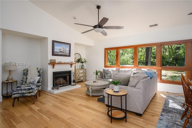 living room featuring ceiling fan, lofted ceiling, and light hardwood / wood-style floors