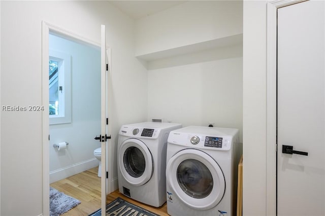 washroom featuring washing machine and clothes dryer and light wood-type flooring