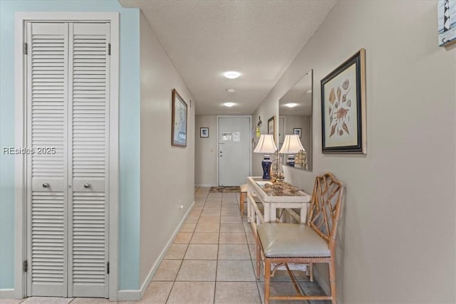 hallway featuring light tile patterned floors and a textured ceiling