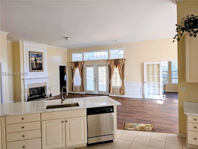 kitchen with dishwasher, sink, light tile patterned floors, light stone countertops, and french doors