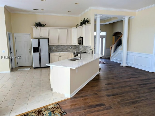 kitchen featuring sink, appliances with stainless steel finishes, white cabinetry, kitchen peninsula, and ornate columns