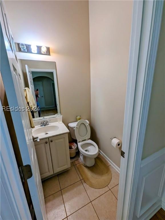 bathroom with tile patterned flooring, vanity, and toilet