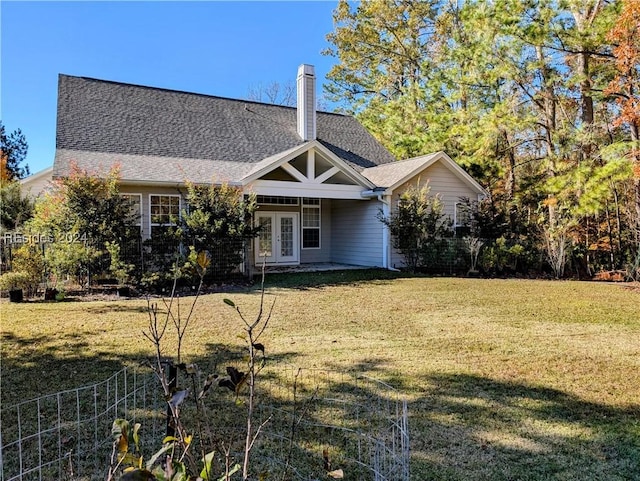 back of property with french doors and a lawn