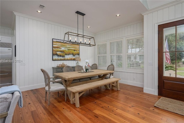 dining space featuring ornamental molding, light hardwood / wood-style floors, a chandelier, and a healthy amount of sunlight