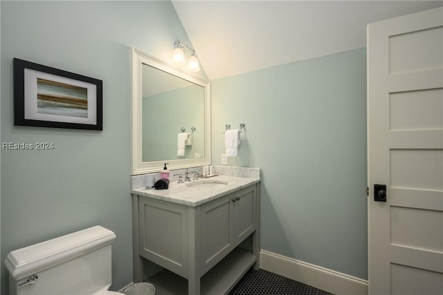 bathroom with vaulted ceiling, vanity, and toilet