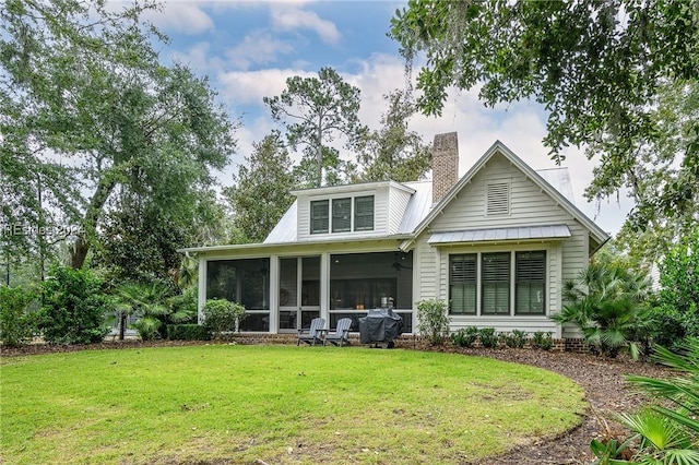 back of house with a sunroom and a lawn