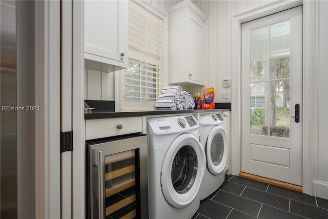 laundry area with cabinets, beverage cooler, washer and clothes dryer, and dark tile patterned flooring