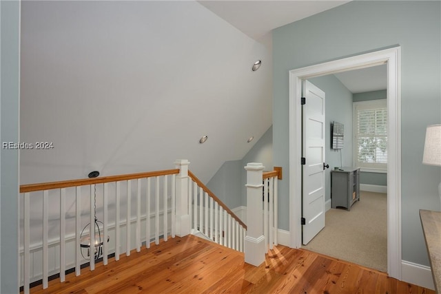 stairs featuring lofted ceiling and hardwood / wood-style floors