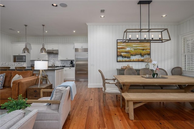 dining room featuring ornamental molding and light wood-type flooring