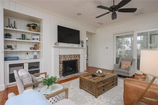 living room featuring a fireplace, light hardwood / wood-style flooring, and ornamental molding