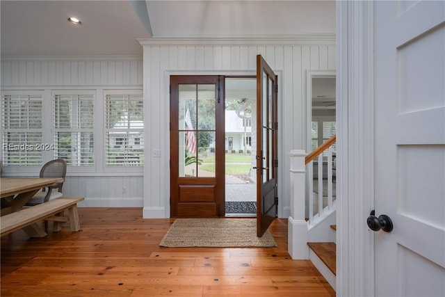 foyer featuring ornamental molding, light wood-type flooring, and a wealth of natural light