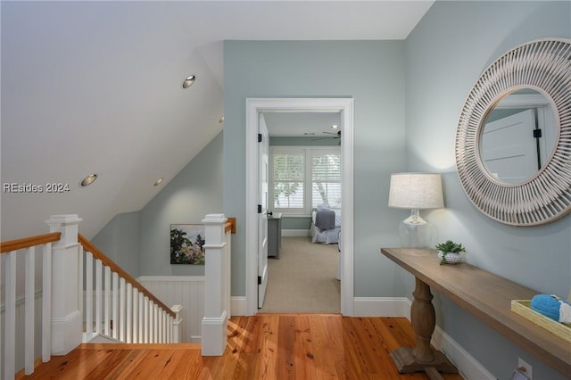 corridor with lofted ceiling and light hardwood / wood-style flooring