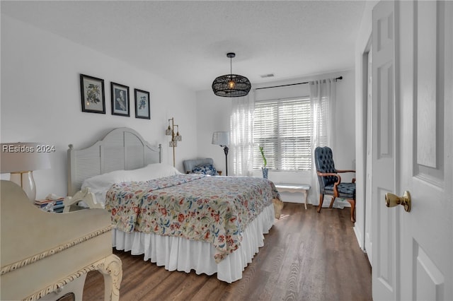 bedroom featuring dark hardwood / wood-style floors and a textured ceiling