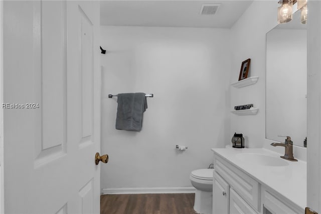 bathroom featuring wood-type flooring, vanity, and toilet