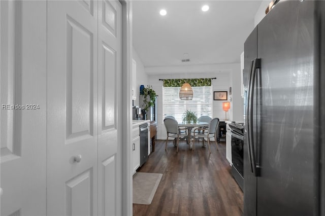 kitchen with white cabinetry, decorative light fixtures, dark hardwood / wood-style floors, and appliances with stainless steel finishes