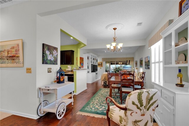 dining room featuring a notable chandelier, dark hardwood / wood-style floors, and a textured ceiling