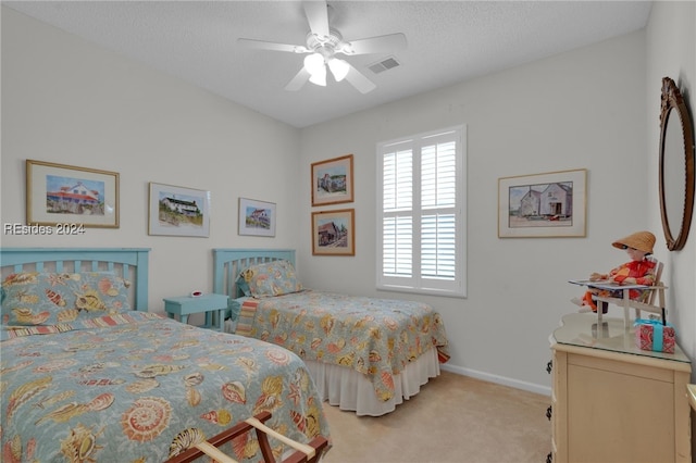 carpeted bedroom with ceiling fan and a textured ceiling