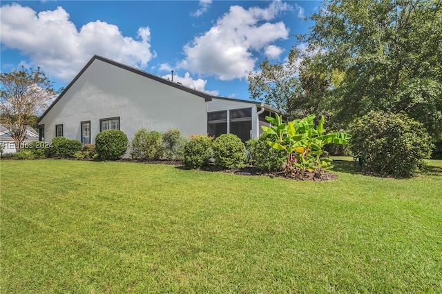 view of property exterior with a sunroom and a lawn