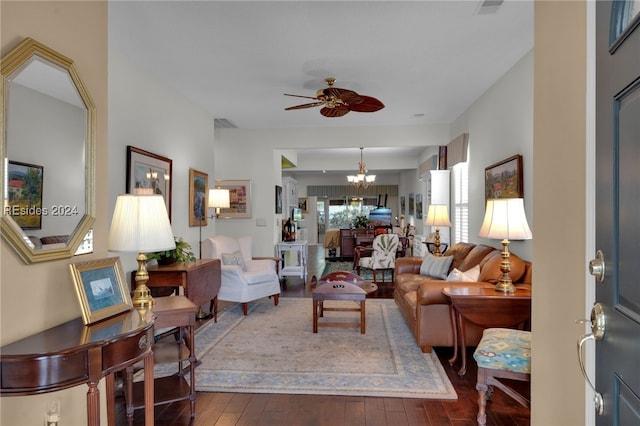 living room with ceiling fan with notable chandelier and hardwood / wood-style floors