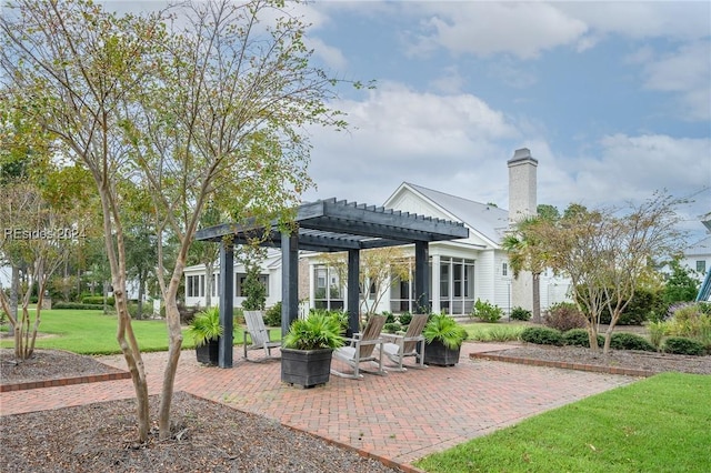 rear view of house featuring a patio, a lawn, and a pergola