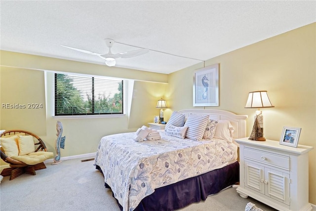 carpeted bedroom with a textured ceiling and ceiling fan