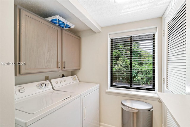 laundry room featuring cabinets, a textured ceiling, washer and dryer, and a wealth of natural light