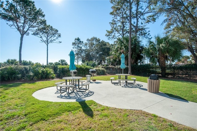 view of property's community with a patio area and a lawn