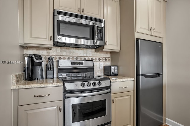 kitchen featuring appliances with stainless steel finishes, backsplash, and light stone counters